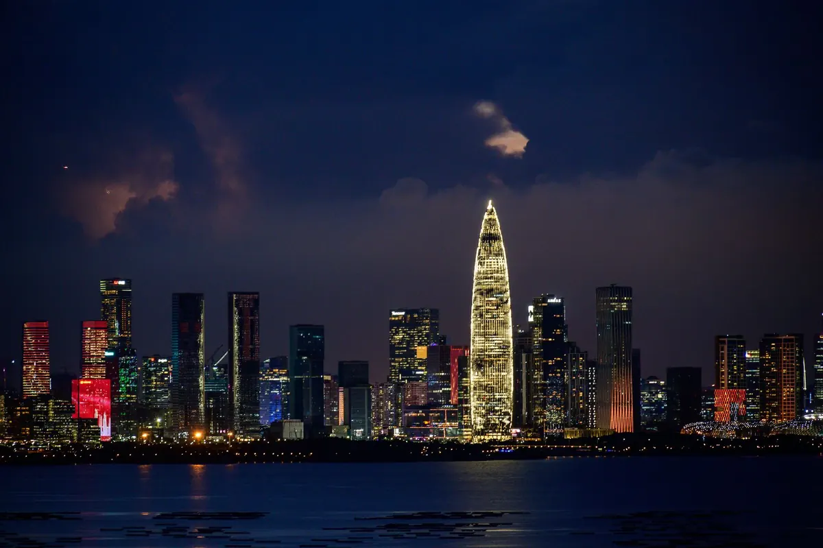 Illuminated skyscrapers packed along a city waterfront at night.