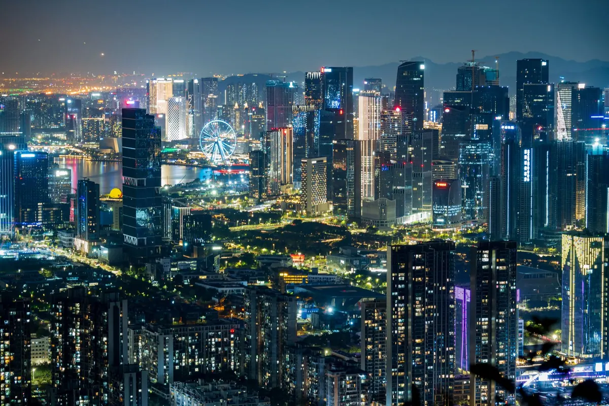 A dense skyline of lit towers photographed from above at night.