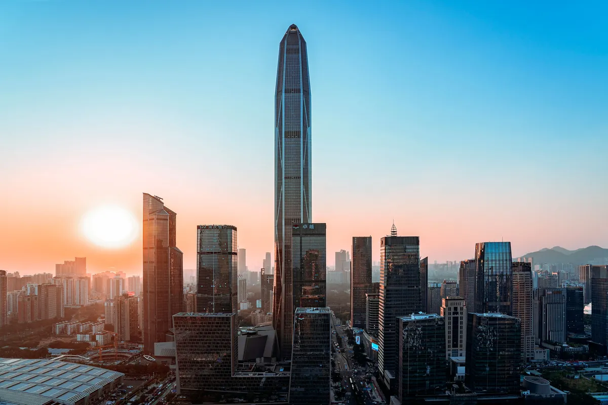 The Shenzhen skyline at sunset with the city's tallest towers in silhouette.