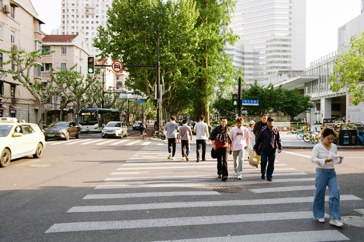 Stock photograph of pedestrians crossing a busy street in Shanghai.