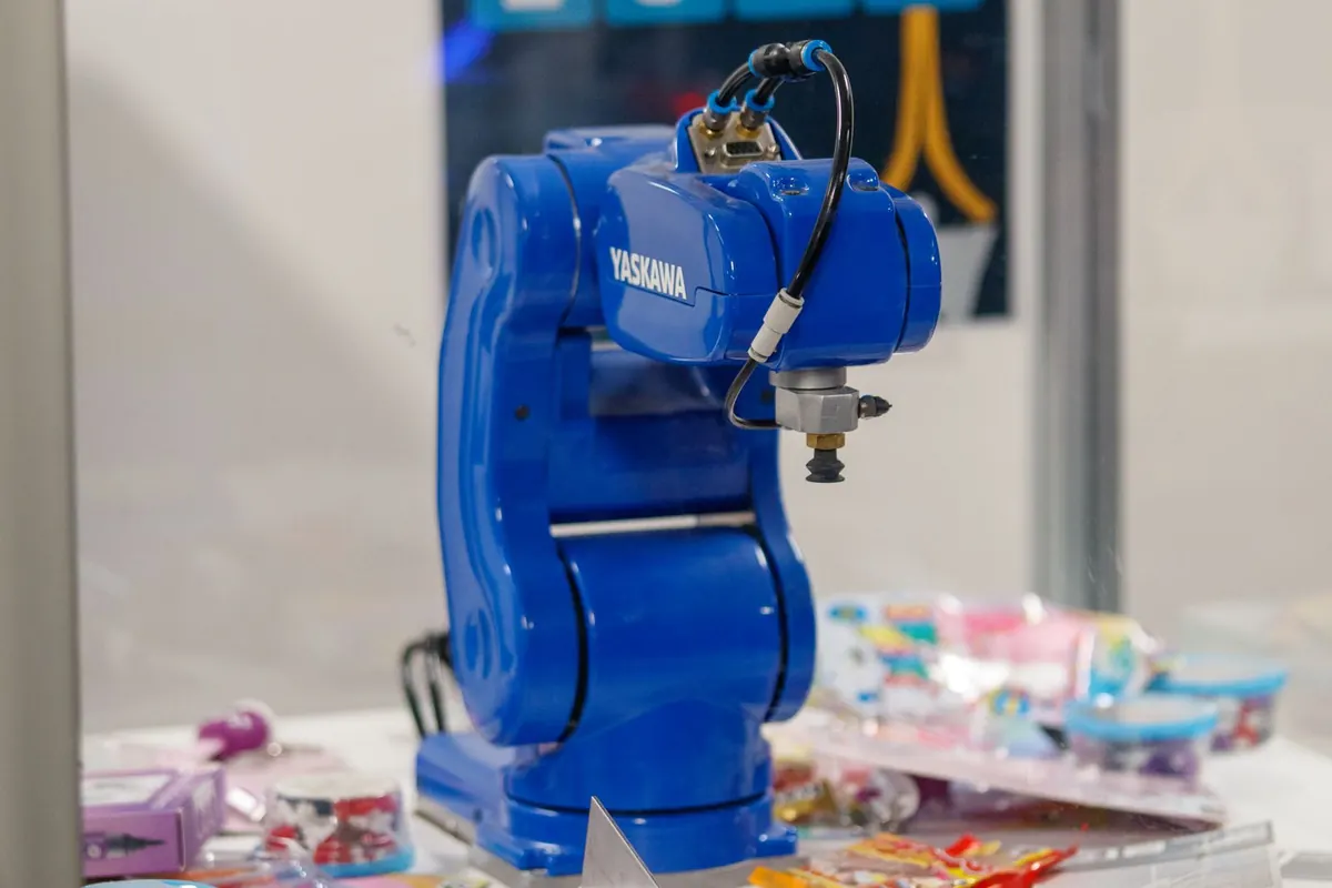 Stock photograph of a blue industrial robot arm in a glass display case.