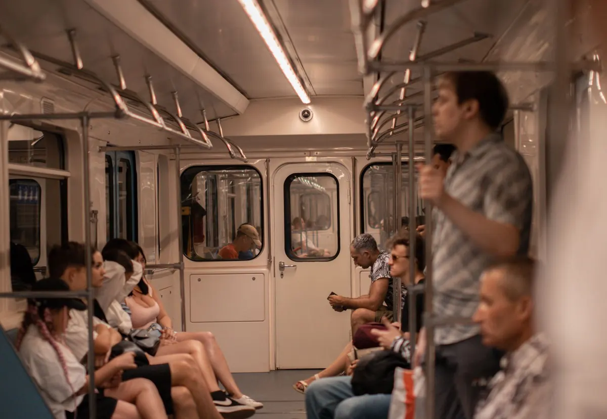 Commuters sitting and standing inside a metro carriage